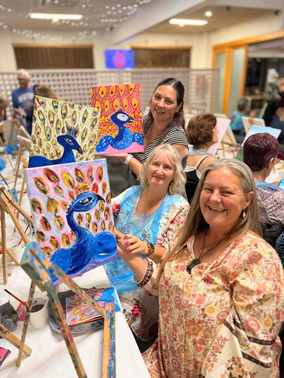 Childers' Paint and Sip customers smiling with their painted artwork