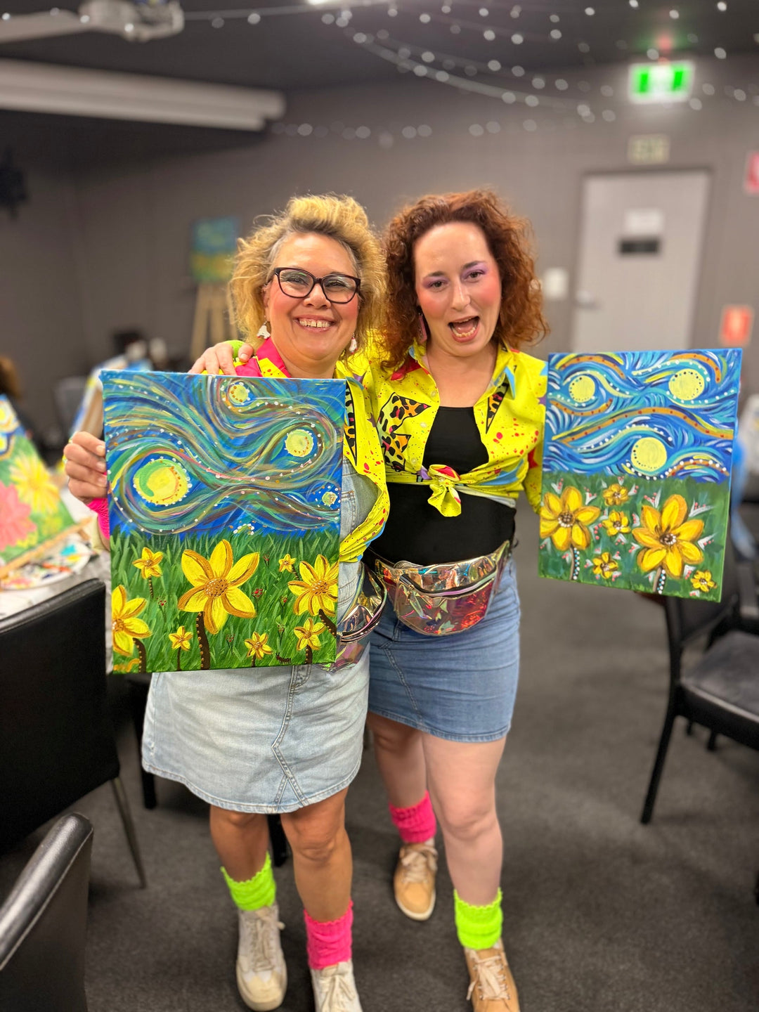 Attendees at Mt Isa Paint and Sip at Buffs Club by Paint Juicy smiling with their vibrant artwork