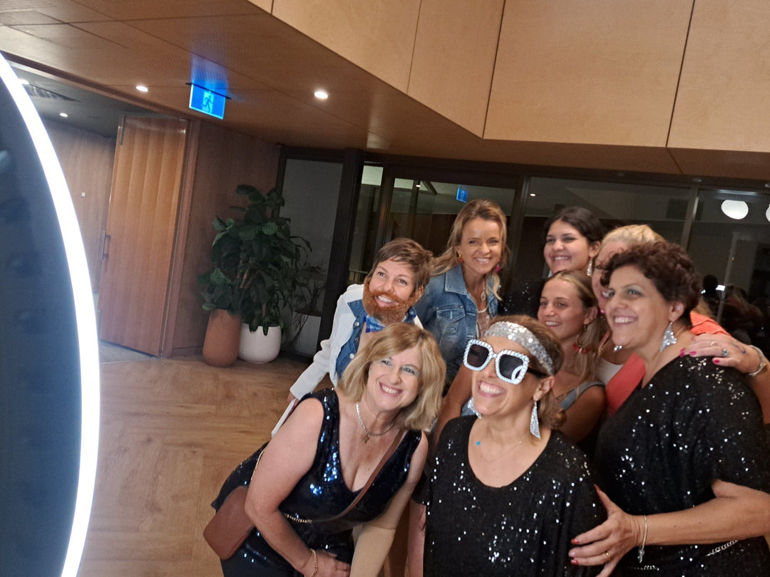 Ladies smiling at a camera to take a photo