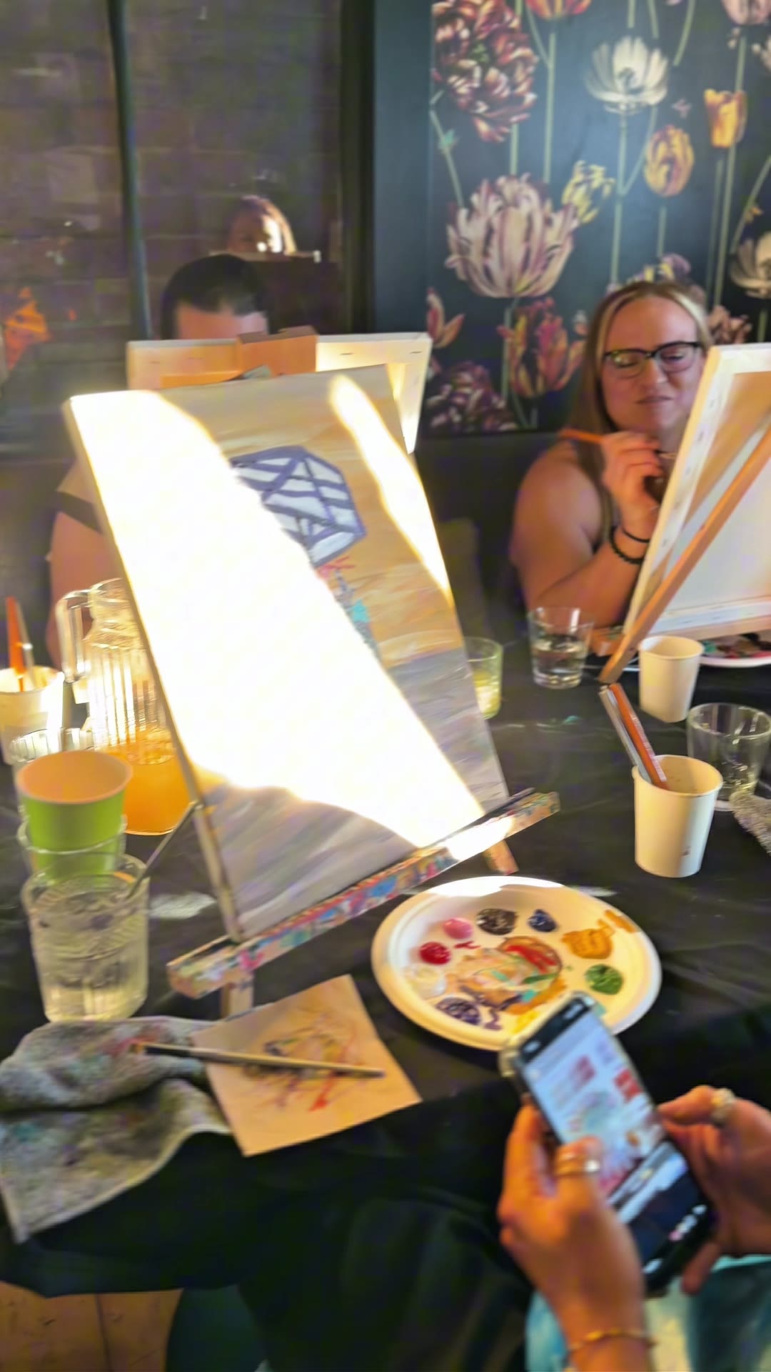 A guest painting a flower cart canvas in the sunlit private room at the Brisbane hens paint and sip at Covent Garden, West End