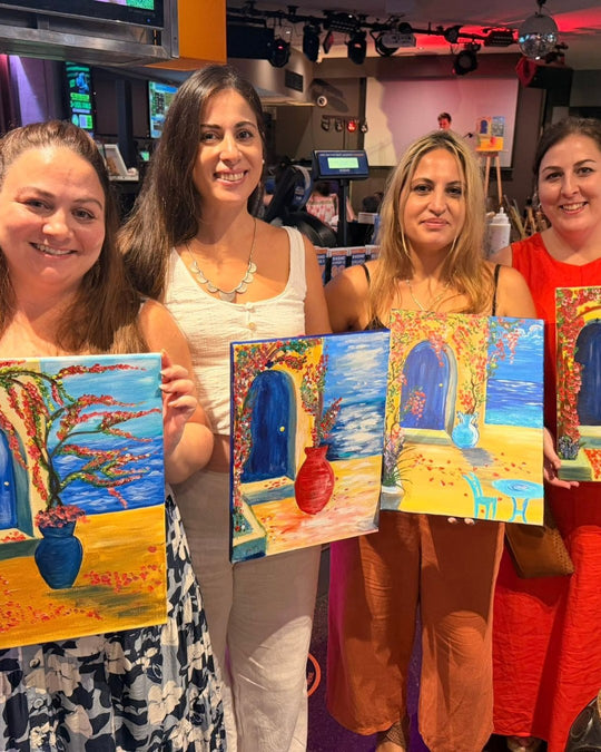 Paint Juicy guests holding their finished Santorini Door paintings at a paint and sip night, photo 2 of 6
