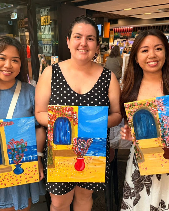 Paint Juicy guests holding their finished Santorini Door paintings at a paint and sip night, photo 3 of 6