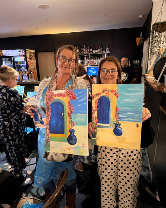 Paint Juicy guests holding their finished Santorini Door paintings at a paint and sip night, photo 5 of 6