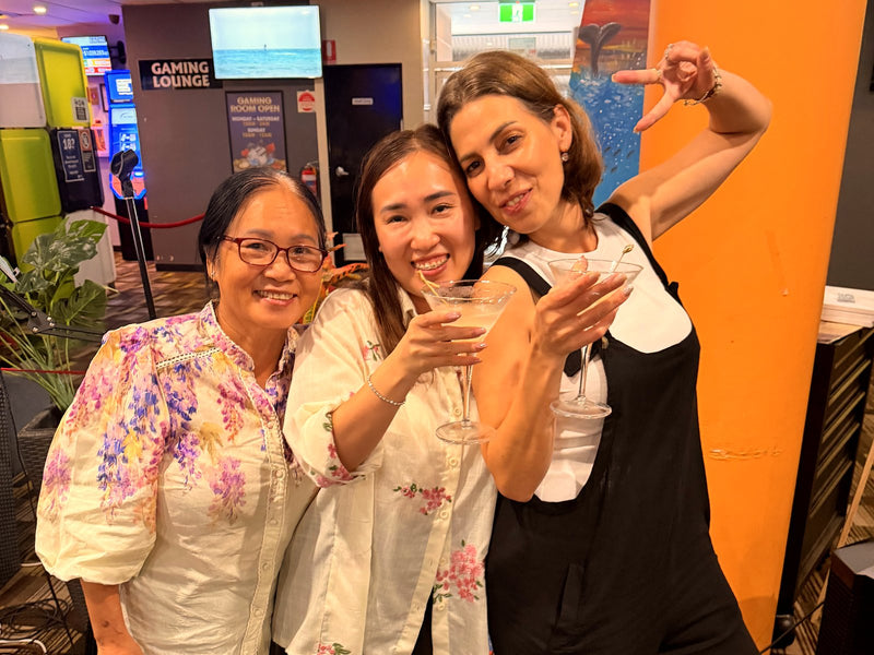 3 women smiling with cocktails