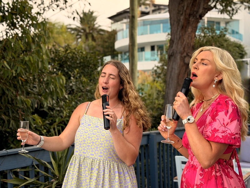 Two women singing karaoke